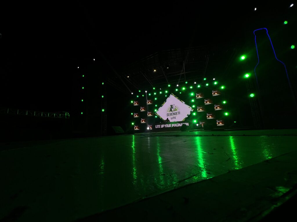 Nighttime stage at 'Lite Your Imagination' event with LED screens brightly lit while surrounding stage lights are off, creating a striking visual focus.
